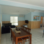 the living area is adjacent to the dining area and kitchen