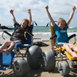 two children using the beach wheelchairs