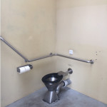 rotary toilet has rear and side rails