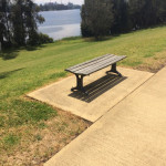 mavromattes bench along riverside path with water views